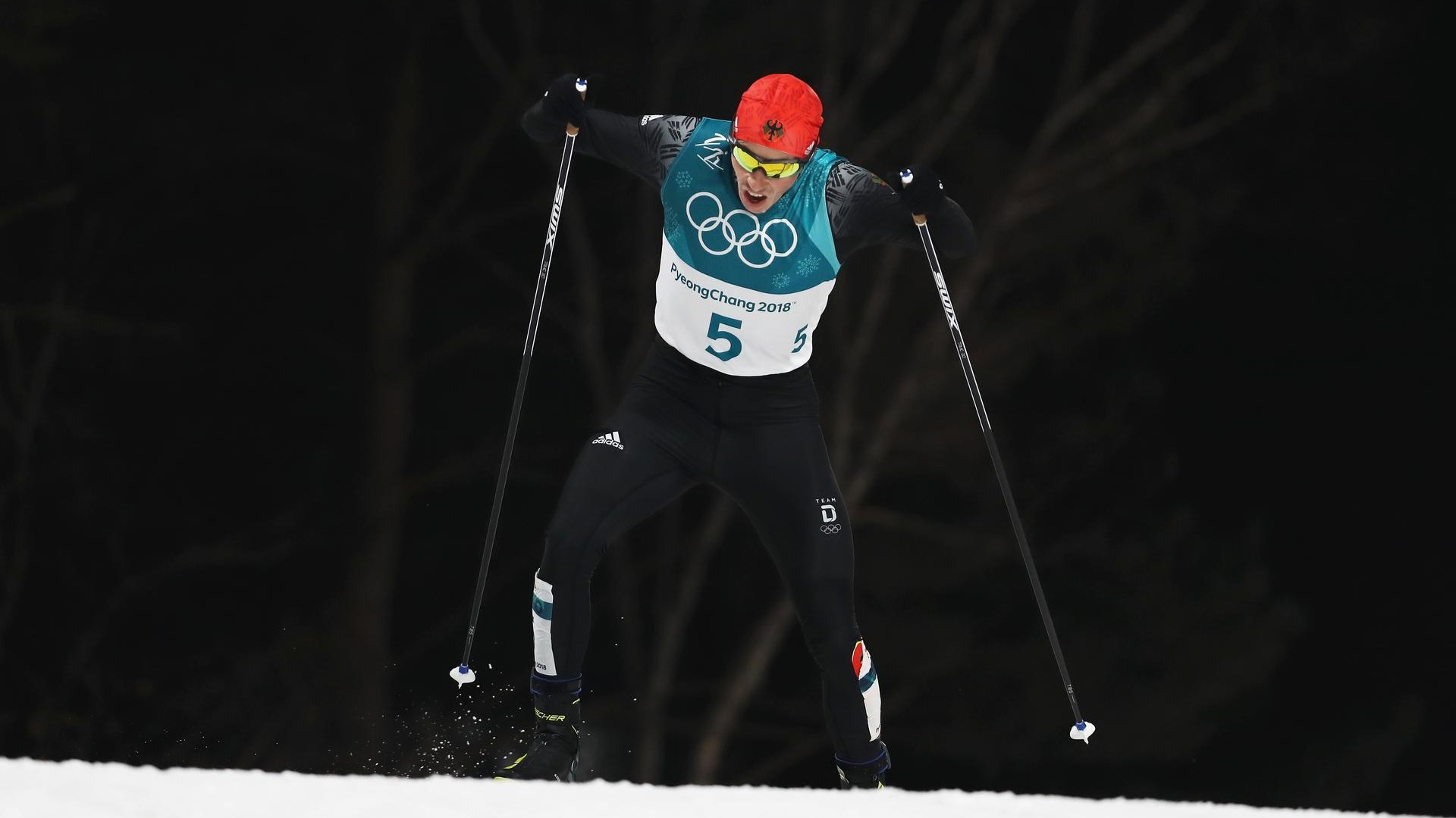 Atleta di sci di fondo impegnato in una gara alle Olimpiadi