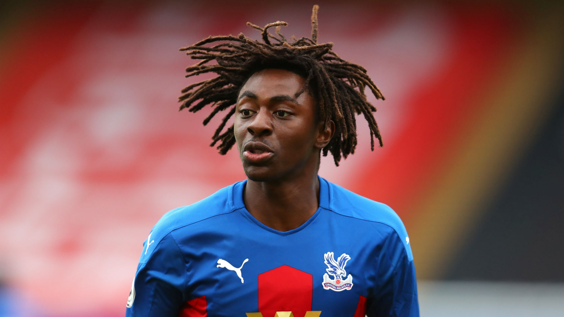  A headshot of Eberechi Eze, a professional soccer player, who has long dreadlocks and is wearing a blue and red jersey.