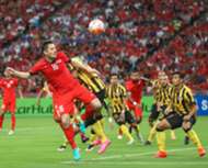 Singapore's Daniel Bennett winning a header againt Malaysia's Shahrul Saad