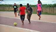 South African kids playing football by the beach