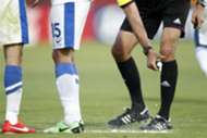 A referee uses vanishing spray during a football match